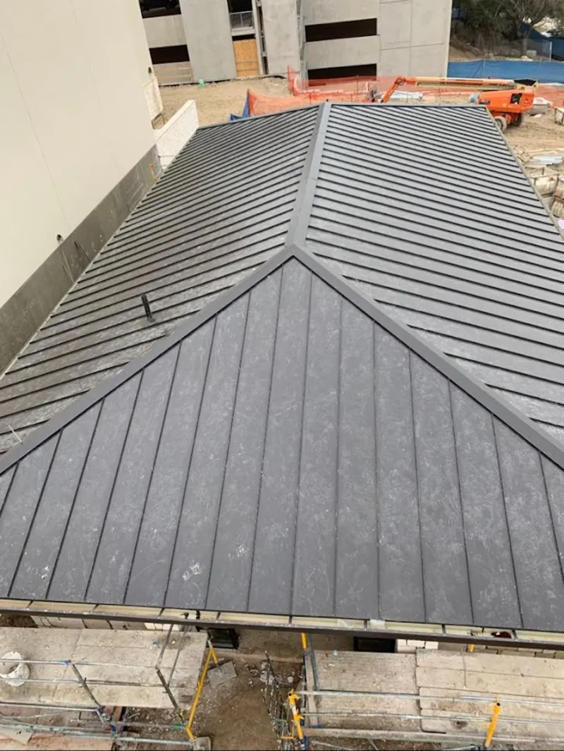 Commercial metal roof construction with crane equipment in North Fort Lewis